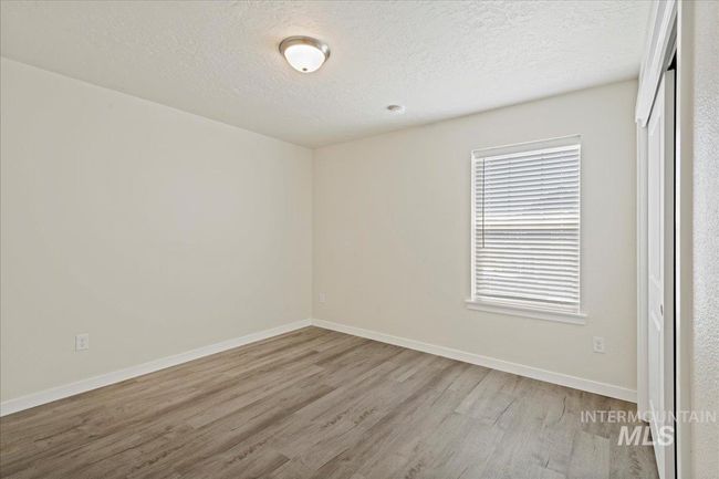 Unfurnished bedroom with light wood-style flooring, a closet, and a textured ceiling | Image 9