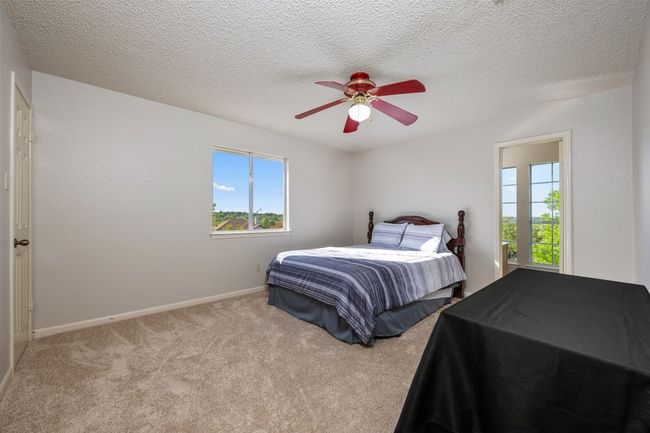 Bedroom with baseboards, a ceiling fan, carpet flooring, and a textured ceiling | Image 23