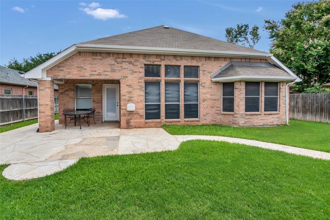 Back of property featuring a fenced backyard, a patio, brick siding, and roof with shingles | Image 37