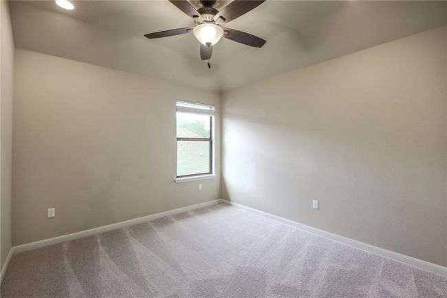 Carpeted empty room featuring a ceiling fan and baseboards | Image 25