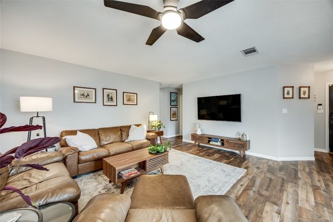 Living room with a ceiling fan, wood finished floors, and baseboards | Image 7