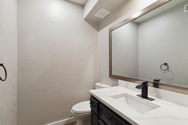 Bathroom featuring toilet, a textured wall, and vanity | Image 18