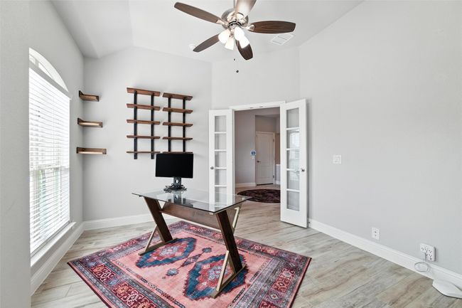 Office area with french doors, healthy amount of natural light, a ceiling fan, light wood-style flooring, and vaulted ceiling | Image 32