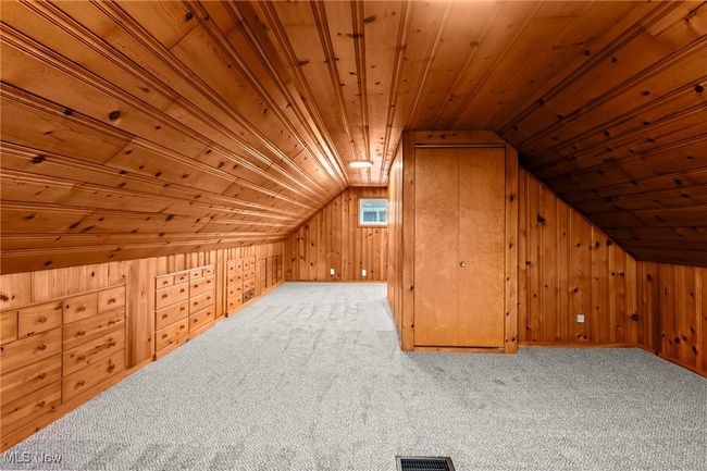 Bonus room featuring wooden ceiling, wood walls, carpet, and vaulted ceiling | Image 31