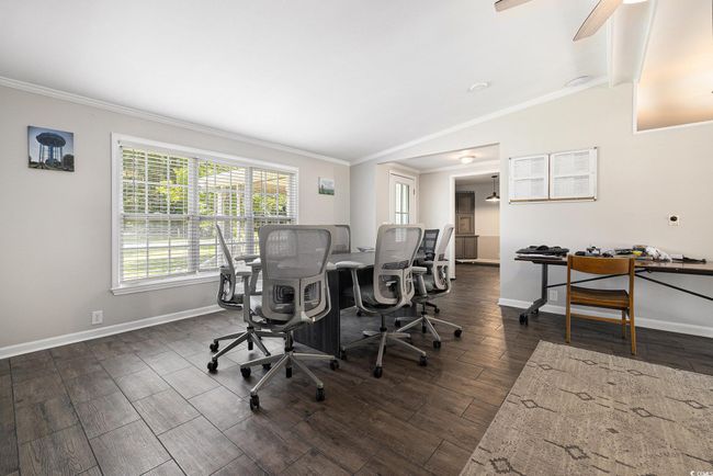 Office space featuring ornamental molding, dark wood-style flooring, and a ceiling fan | Image 11