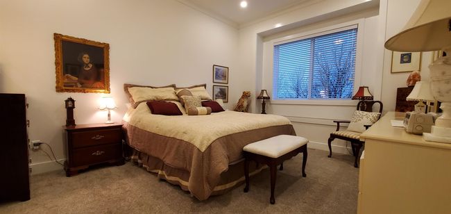 Bedroom with baseboards, crown molding, and light carpet | Image 12