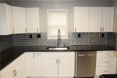 Kitchen featuring dishwasher, decorative backsplash, white cabinets, and sink | Image 3