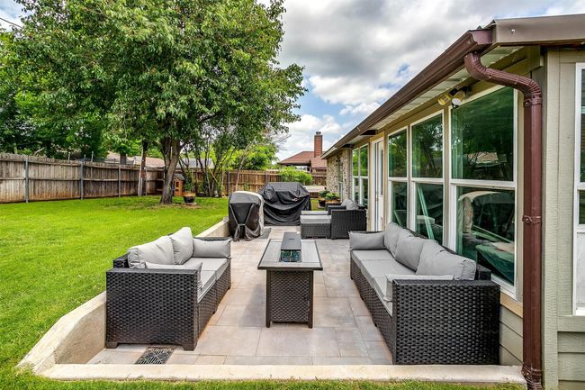 Fenced backyard with an outdoor living space with a fire pit, area for grilling, and a patio | Image 4