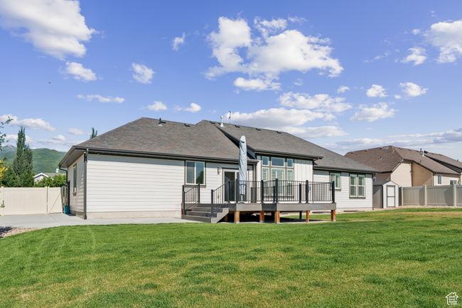 Rear view of house featuring a storage unit, a deck, a patio, and roof with shingles | Image 35