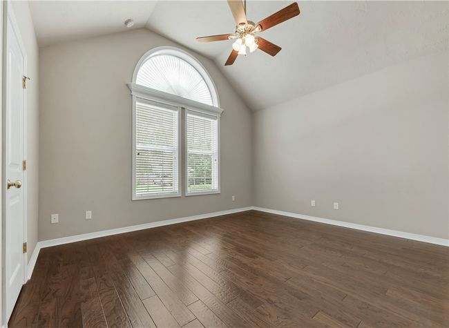 Spare room featuring plenty of natural light, ceiling fan, lofted ceiling, dark wood finished floors, and baseboards | Image 27
