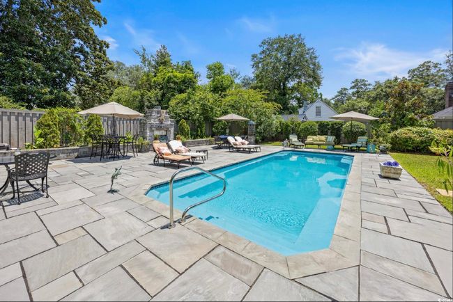View of swimming pool featuring a patio and view of wooded area | Image 9