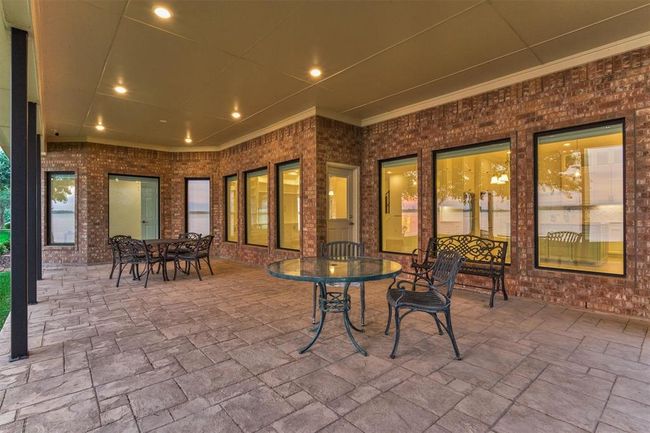 The spacious back porch easily accommodates multiple seating areas, making it ideal for gatherings and entertaining. High-end picture windows feature a low U-factor and tinted glass for optimal energy efficiency. Additionally, the porch is pre-plumbed with a gas line, ready for a future outdoor kitchen installation. | Image 43