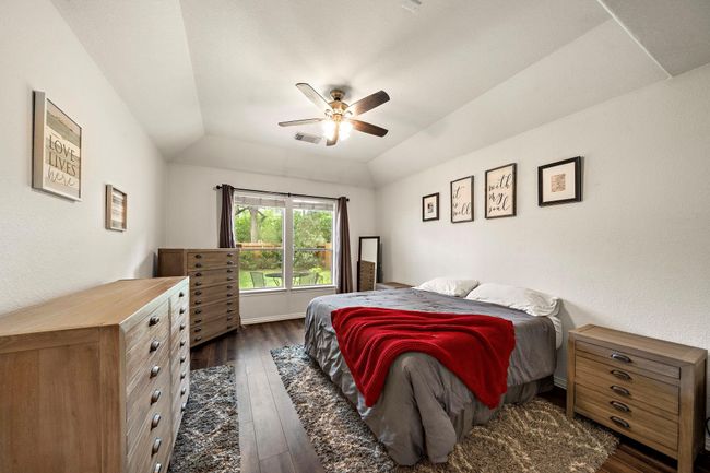 Spacious primary bedroom with vaulted ceilings and a great view of the backyard. | Image 11