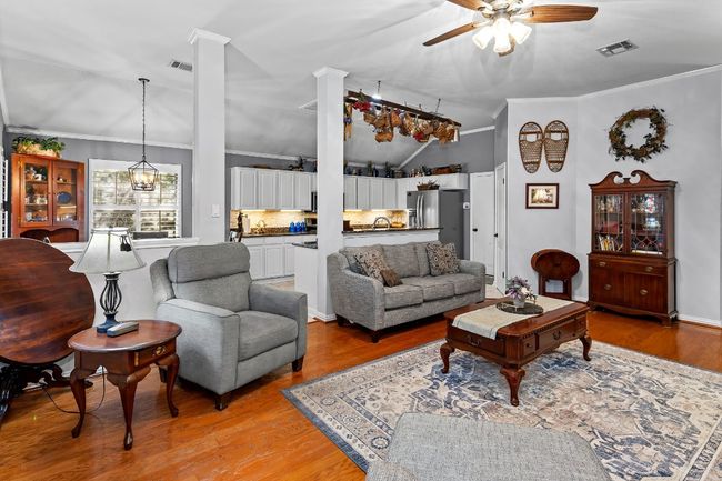 Living room with crown molding, ceiling fan, and light hardwood / wood-style flooring | Image 8