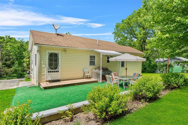 Rear view of property featuring a shingled roof, a lawn, and a deck | Image 27