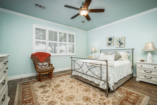 Bedroom featuring wood finish floors, crown molding, and a ceiling fan | Image 10