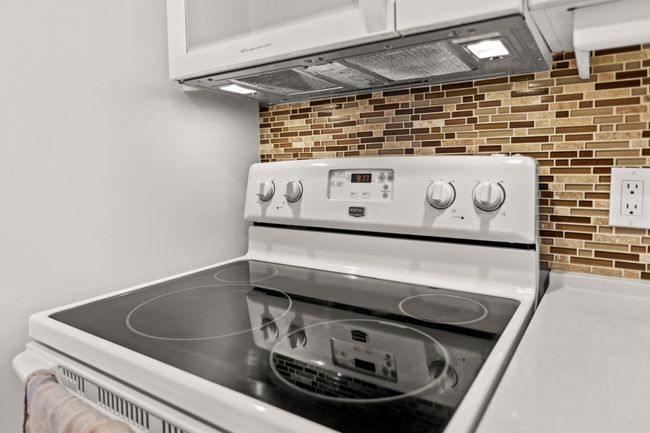 Interior details with white electric stove and white cabinetry | Image 13