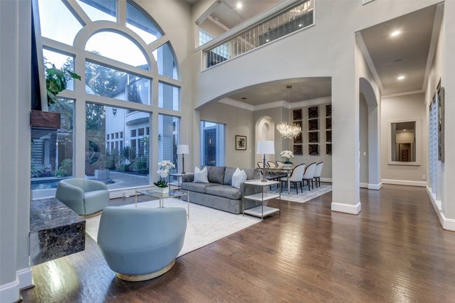 The formal areas provide an elegant first look into the home, away from the business of the daily living spaces. Hardwood flooring has been added to most of the downstairs giving a seamless flow to the home. The glass balcony above gracefully looks down to the formal areas. | Image 6