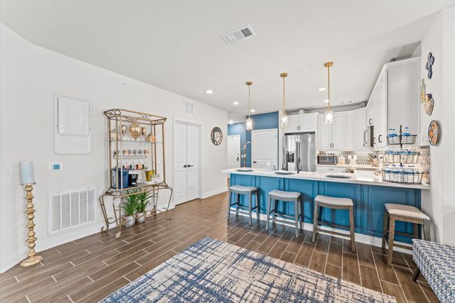 Expansive island with bar seating for four—perfect for hosting or everyday dining—framed by gold-tone lighting and striking color contrast. | Image 5