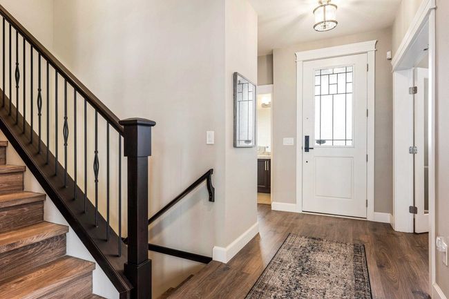 Entrance foyer featuring dark wood-type flooring, baseboards, and stairway | Image 8