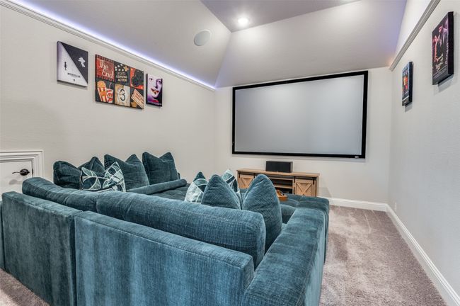 Carpeted cinema room with lofted ceiling and baseboards | Image 21