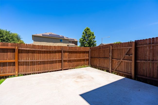 Fenced backyard with a patio | Image 24