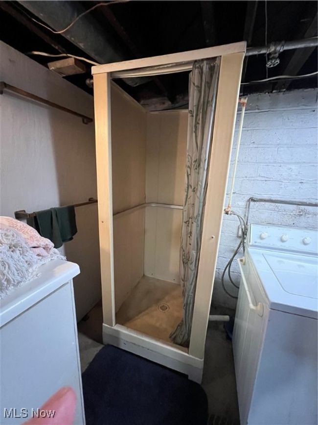 Bathroom featuring washer / dryer, curtained shower, and vanity | Image 16