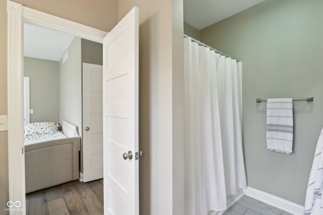 full bathroom featuring connected bathroom, baseboards, and wood finished floors | Image 38