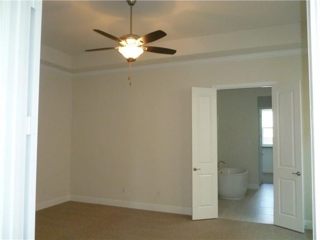 Empty room with ceiling fan, ornamental molding, and baseboards | Image 5