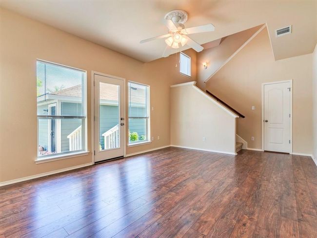 Windows along the side and back wall infuse the main living area is peaceful natural light with tall ceilings and wood floors making it feel open and airy. | Image 11