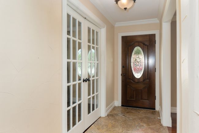 Entryway featuring ornamental molding and stone finish floors | Image 6