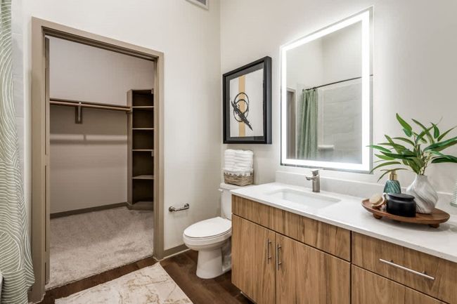 Bathroom with vanity, a shower with curtain, and toilet | Image 9