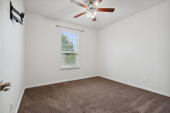 Unfurnished room with dark colored carpet and ceiling fan | Image 24