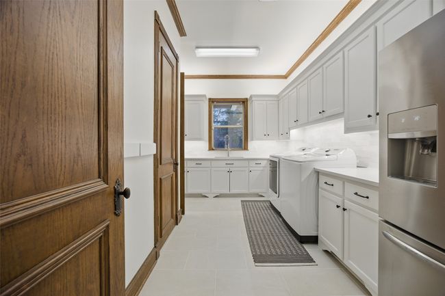 Huge laundry room off the kitchen offers second sink and additional room for freezer. | Image 16