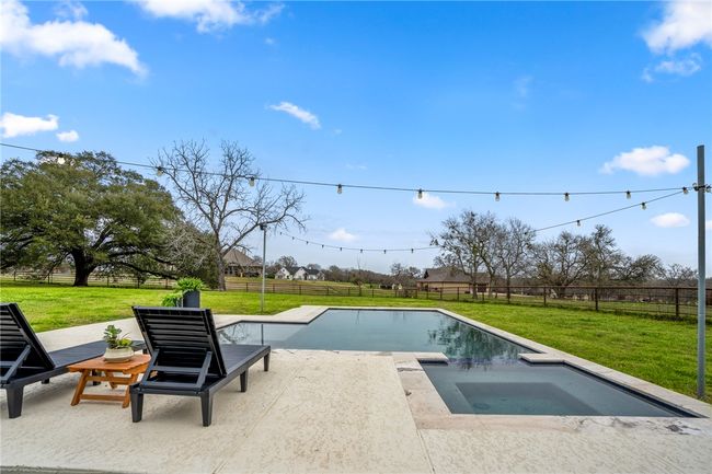 View of swimming pool with an in ground hot tub, a fenced backyard, a lawn, and a patio | Image 48