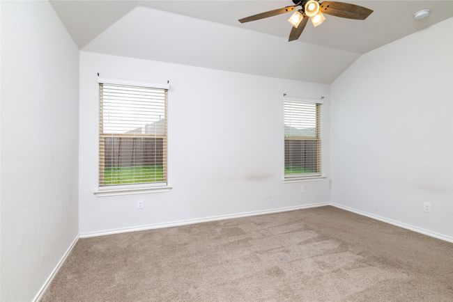 Unfurnished room with carpet, a ceiling fan, lofted ceiling, a smoke detector, and baseboards | Image 22