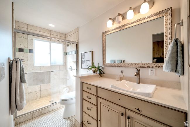 Full bath featuring a shower stall, toilet, tile patterned flooring, and vanity | Image 16