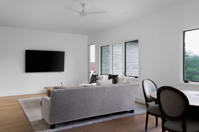 Living area with a ceiling fan and wood finished floors | Image 23