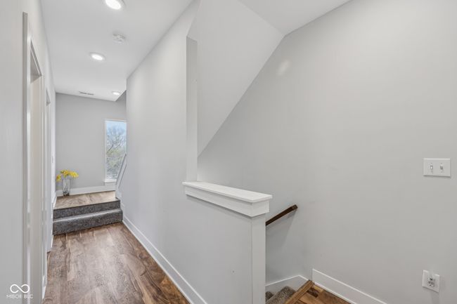 corridor with baseboards, an upstairs landing, and wood finished floors | Image 17