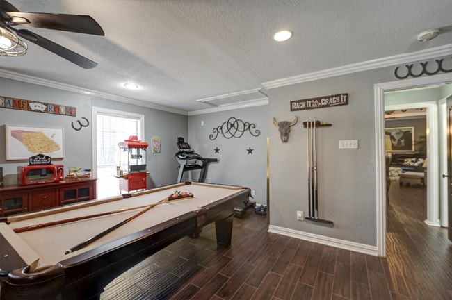Rec room featuring crown molding, ceiling fan, billiards, and dark wood finished floors | Image 28