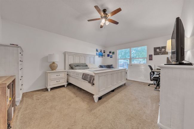 Bedroom featuring light carpet, vaulted ceiling, and ceiling fan | Image 10
