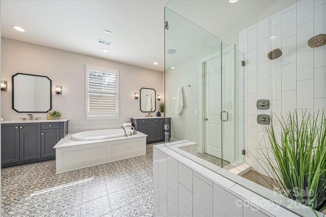 Primary bathroom with a large spa bathtub and dual vanities | Image 18