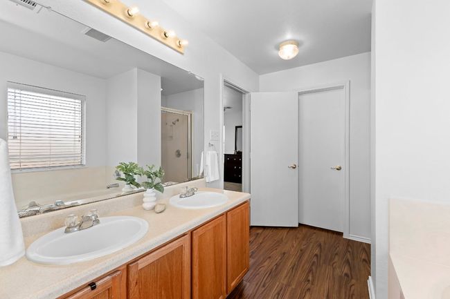 Full bath featuring a shower stall, a bath, wood finished floors, and double vanity | Image 32