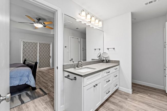 Bathroom featuring a ceiling fan, wood finished floors, vanity, baseboards, and visible vents | Image 18