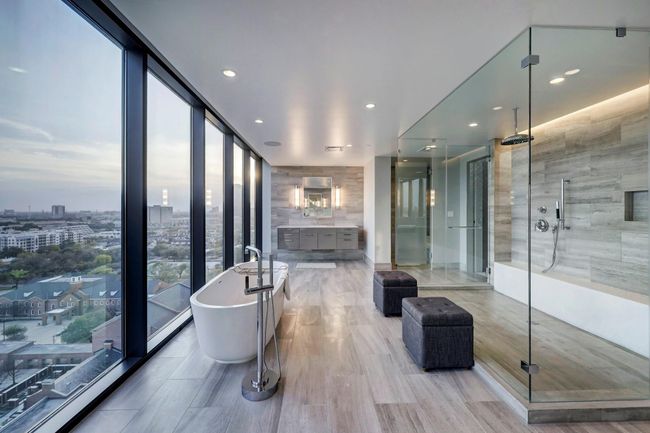 The primary bath rivals those found in a five star resort. Highlights include tile floors, dual Poggenpohl vanities with silestone counters, dual private commode areas, an oversized frameless shower and a freestanding tub with incredible exterior views to the south. | Image 17