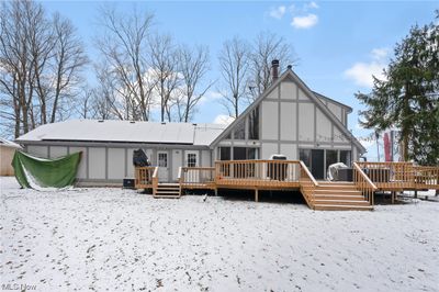 Rear of property featuring a wooden wrap around deck | Image 2