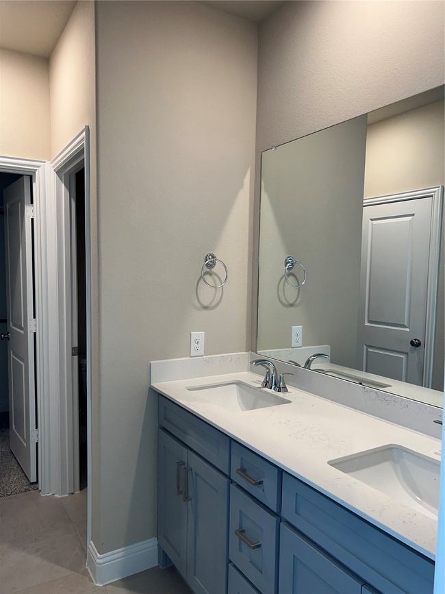Full bath featuring double vanity, baseboards, and a sink | Image 5