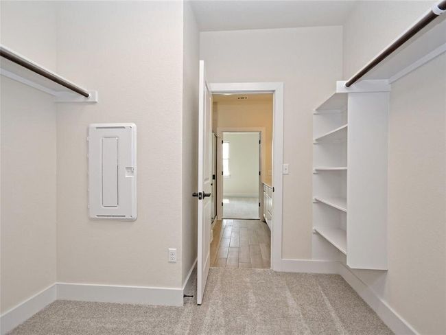Walk in closet with electric panel and carpet floors | Image 10