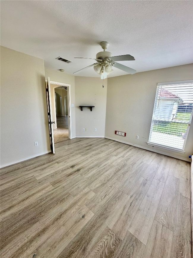 Empty room featuring wood finished floors, ceiling fan, and a textured ceiling | Image 16