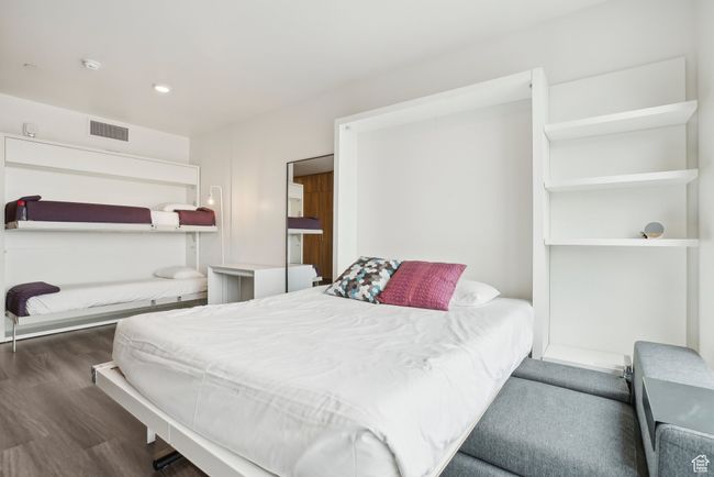 Bedroom with wood finished floors and visible vents | Image 19